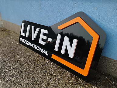 Logo z plastu na ciernom plexiskle